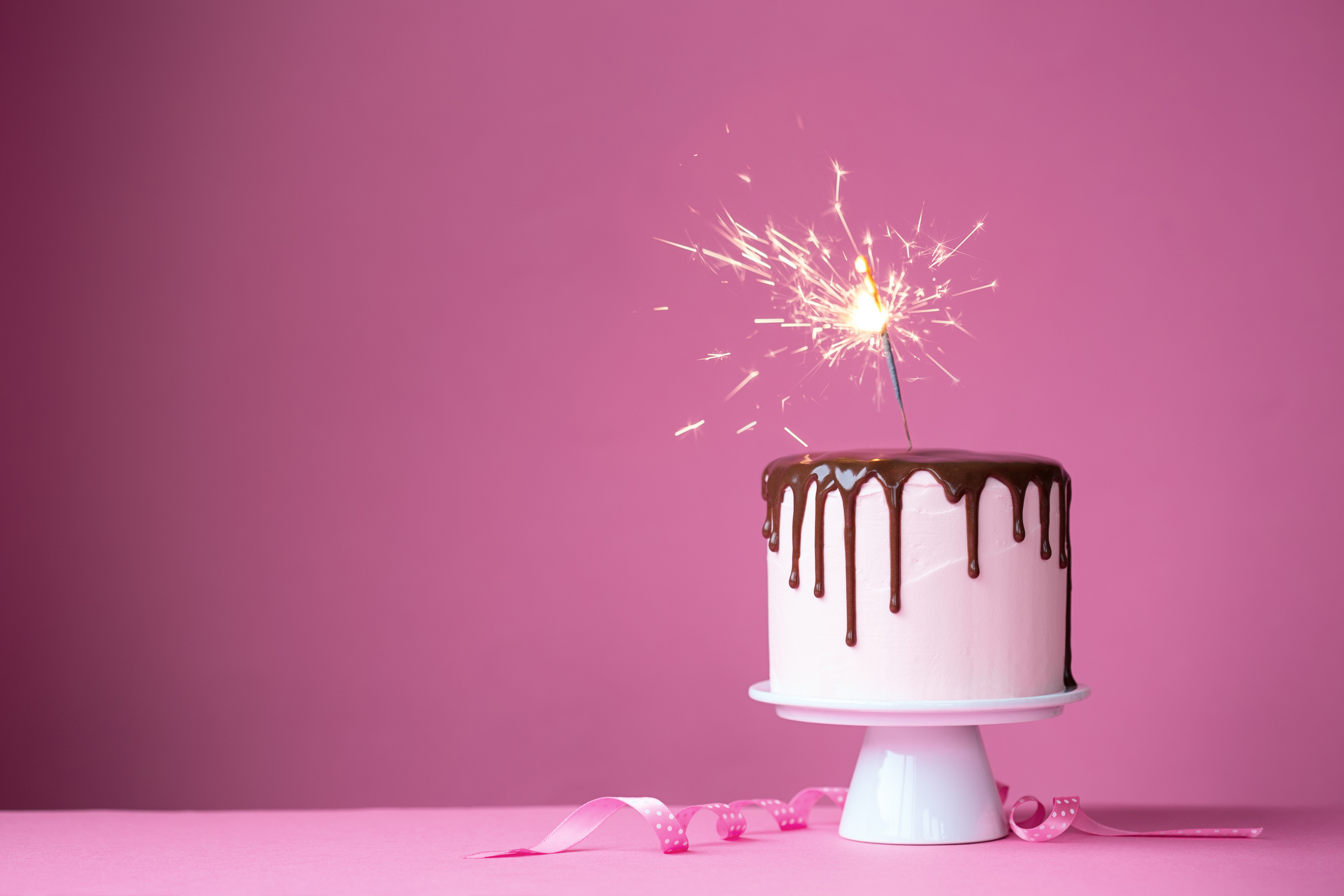 Birthday Cake with Sparkle on Pink Background 